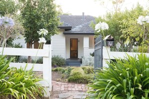 A small house with a front door, a mailbox, and a white picket fence. - Higgins Hideaway—Central Cottage with Garden Oasis (Margaret River)