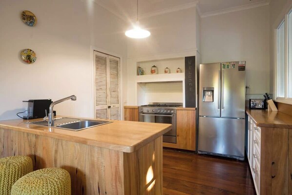 A compact kitchen with a central island, a stove, and a refrigerator.