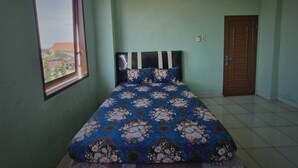 A bedroom with a bed, a window, and a door. - EXPRESS O 91979 Penginapan Tondong Ta (Medan)
