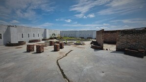 A courtyard with a concrete floor, brick structures, and a clear sky. - EXPRESS O 91979 Penginapan Tondong Ta (Medan)