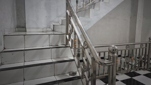 A staircase with a metal railing and a checkered floor. - EXPRESS O 91979 Penginapan Tondong Ta (Medan)