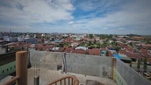 A high vantage point overlooking a densely packed residential area with a variety of building styles and a clear sky. - EXPRESS O 91979 Penginapan Tondong Ta (Medan)