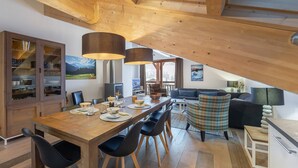 A modern loft with a wooden dining table, black chairs, a sofa, and a fireplace. - MONT BLANC - A08 - apartment for 8 people with 3 bedrooms (LA CHAPELLE D ABONDANCE)