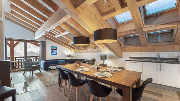 A spacious dining area with a wooden table and chairs, a high ceiling with exposed beams, and large windows allowing natural light. - MONT BLANC - A08 - apartment for 8 people with 3 bedrooms (LA CHAPELLE D ABONDANCE)