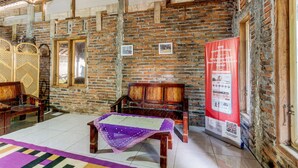 A room with exposed brick walls, wooden furniture, and a tiled floor. - OYO Homes 91157 Desa Wisata Bendosari Kendal (Bendosari)