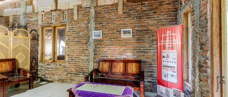 A room with exposed brick walls, wooden furniture, and a tiled floor.