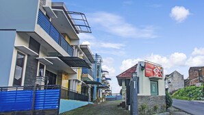 A modern building with a sign for "Forzando House" and a cobblestone path leading to the entrance.