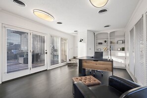 A modern kitchen with a central island, white cabinetry, and a built-in bench.