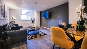 Una sala de estar moderna con sofá, mesa de centro y comedor.