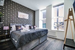 A bedroom with a bed, a window, and a radiator. - 1 Bedroom apartment with an open plan kitchen, diner, and lounge. (York)