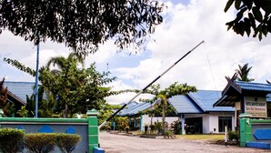 A hotel with a blue roof and a signboard.
