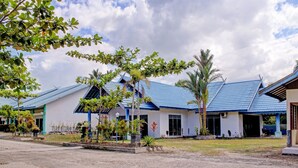 A row of white buildings with blue roofs and a clear sky.