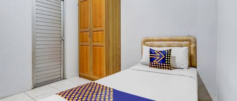 Une chambre à coucher avec un lit, une armoire et une porte.
