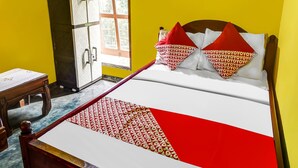 A bed with a patterned bedspread, a wooden headboard, and two pillows with a red and white pattern. - Hotel O Kampung Wisata Ekologi Puspa JagadNearGunung Kelud (Gandusari)