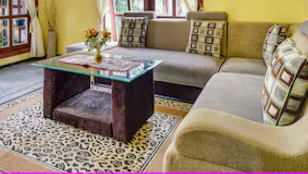 A living room with a sofa, a glass coffee table, and a patterned rug. - Hotel O Kampung Wisata Ekologi Puspa JagadNearGunung Kelud (Gandusari)