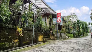 A rustic building with a metal roof, surrounded by lush greenery and a dirt path. - Hotel O Kampung Wisata Ekologi Puspa JagadNearGunung Kelud (Gandusari)