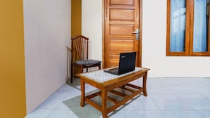 A wooden door, a chair, and a table with a laptop. - OYO Homes 91008 Eco Tourism Desa Cibodas Babakan Gentong 1 Syariah (Lembang)