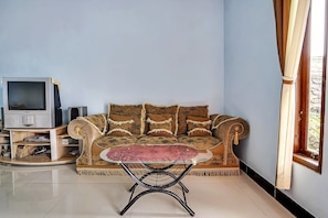 A living room with a sofa, a television, and a coffee table. - OYO Homes 91009 Eco Tourism Desa Cibodas Areng 4 Syariah (Lembang)