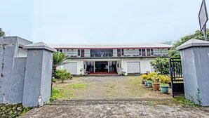 A two-story building with a red roof, a front entrance, and a gated driveway. - Hotel O Panorama Rinjani LodgeNearTaman Nasional Gunung Rinjani (Sembalun Lawang)