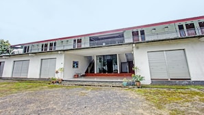 A building with a covered entrance, potted plants, and a staircase leading to a balcony. - Hotel O Panorama Rinjani LodgeNearTaman Nasional Gunung Rinjani (Sembalun Lawang)