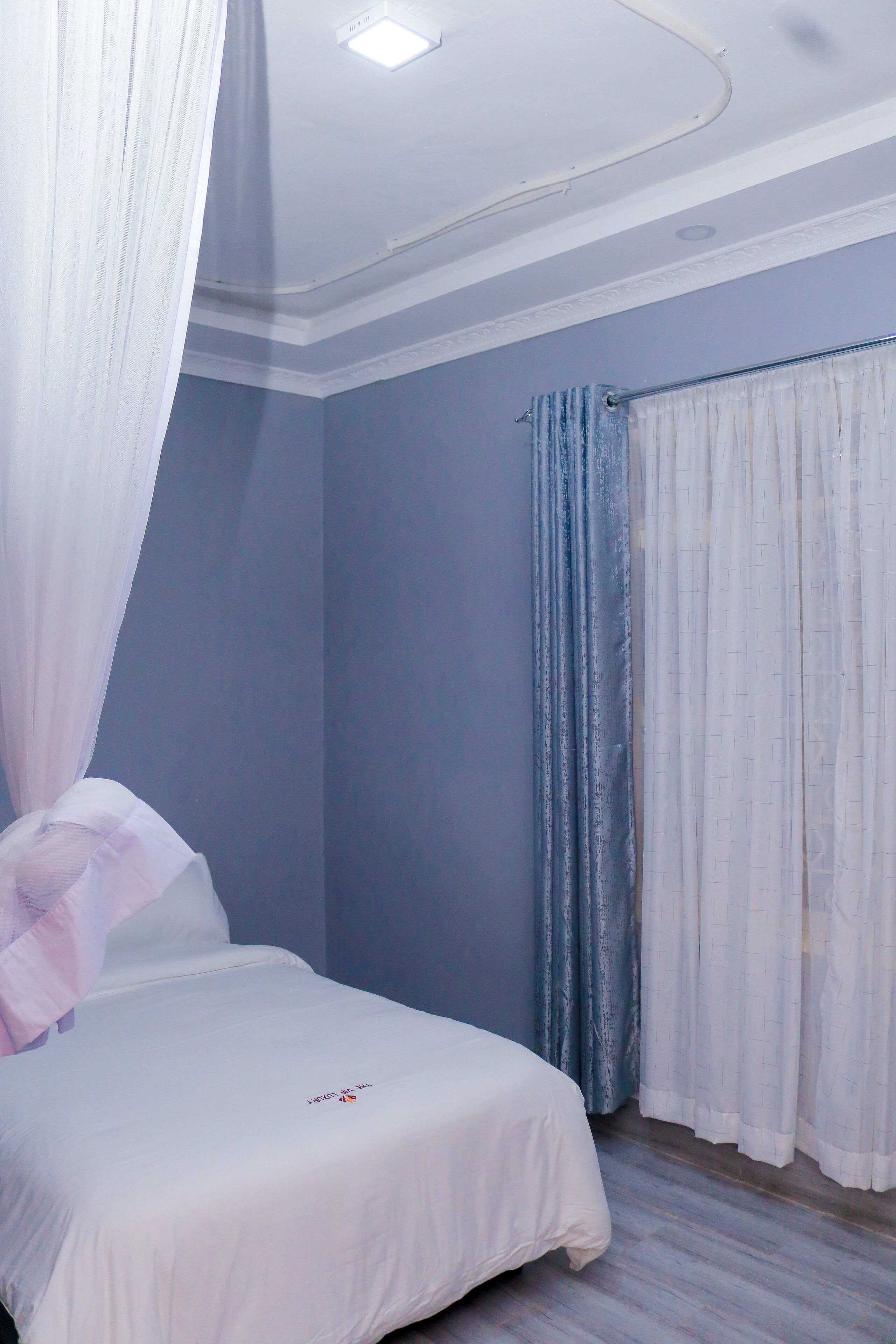 A bedroom with a bed, a canopy, and curtains.