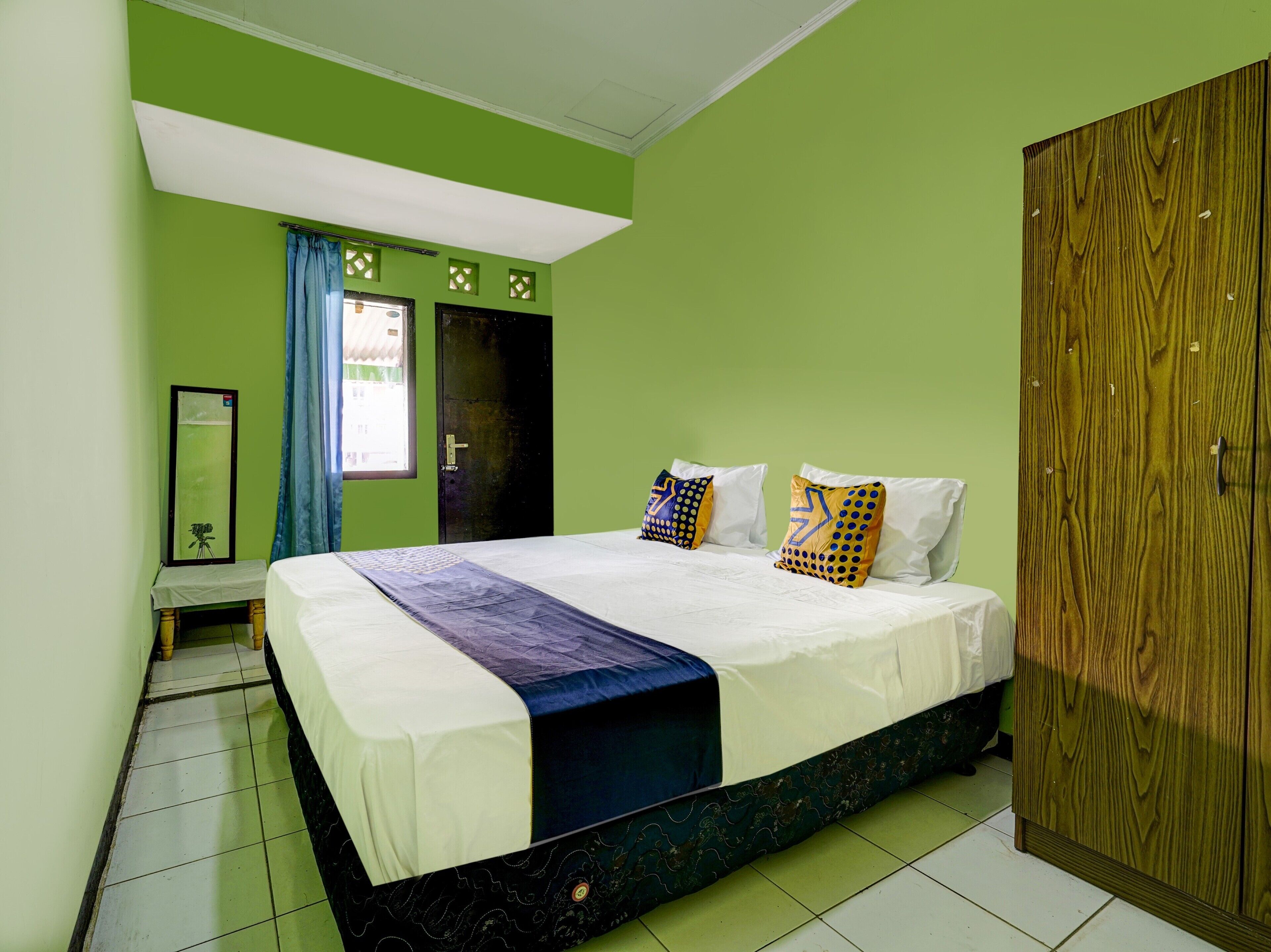 A room with a bed, a wardrobe, and a mirror.