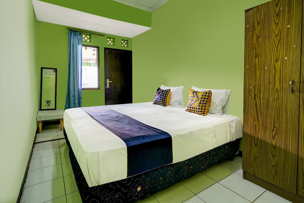 Une chambre à coucher avec un lit, une armoire et un miroir.