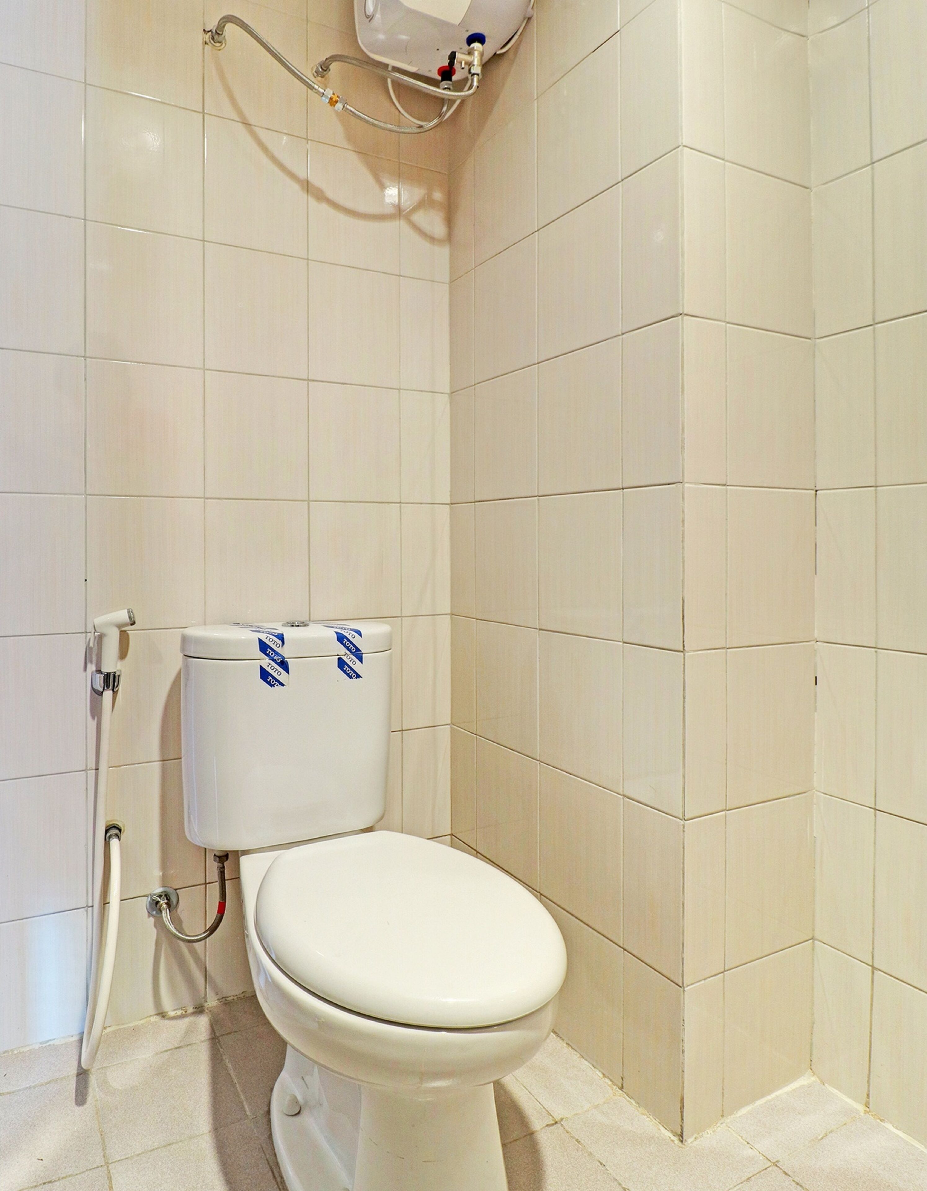 A bathroom with a toilet, a shower, and tiled walls.