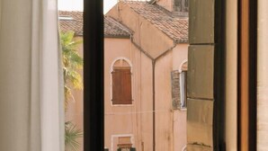 Ein Fenster mit Blick auf ein Gebäude mit Ziegeldach und Mauerwerk.