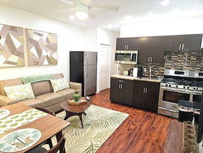 Compact living space with a modern kitchen, sofa, and coffee table.
