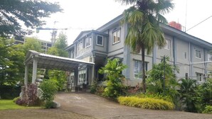 A two-story building with a covered entrance and a paved driveway. - Hotel O Subur (Makassar)