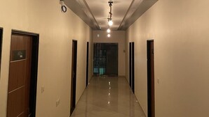 A hallway with a tiled floor, doors on both sides, and a ceiling light fixture.
