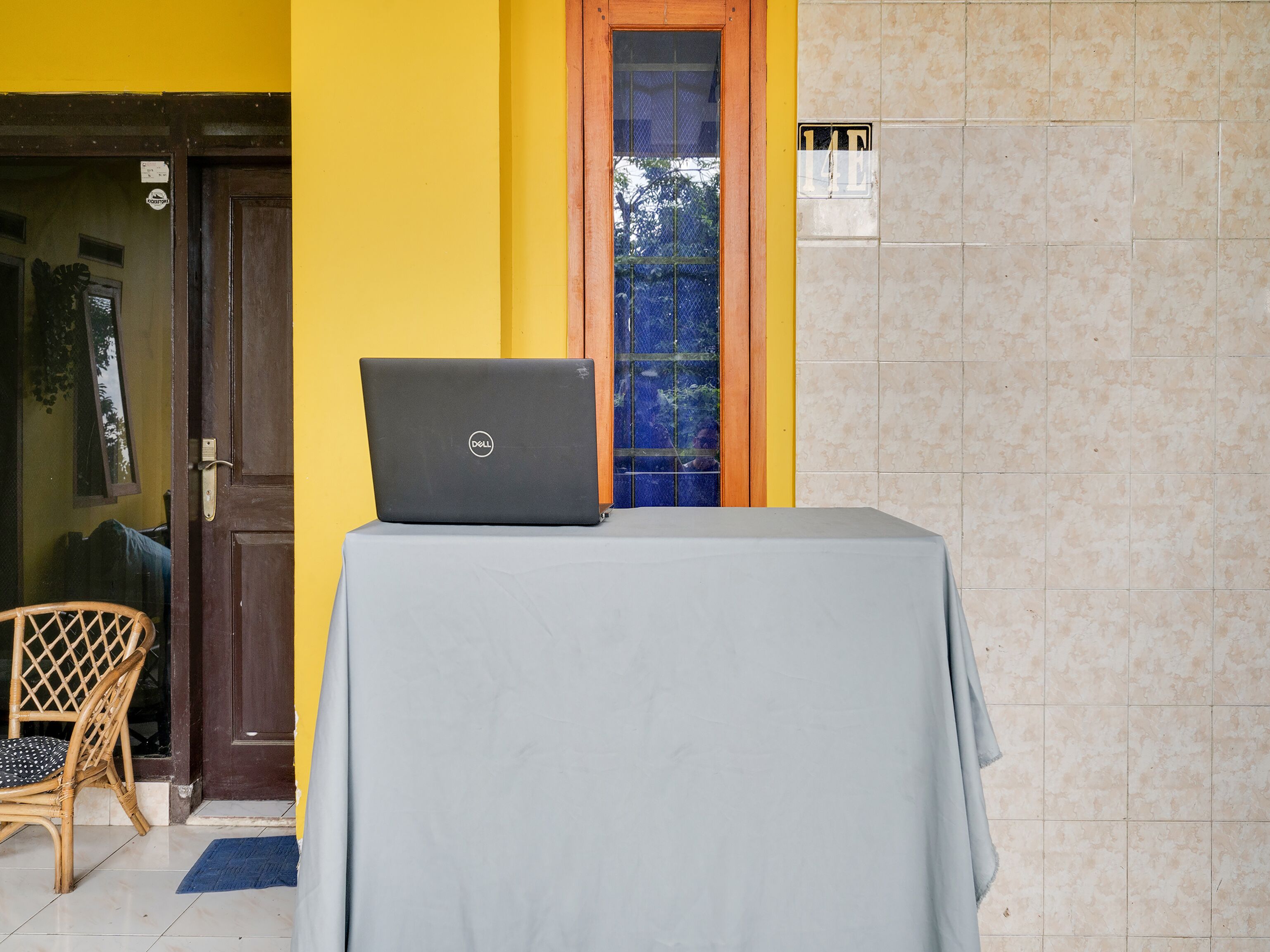 A room with a laptop on a table, a door, and a window with a view.