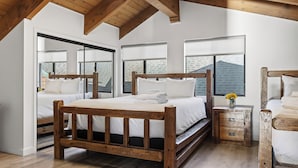 Un dormitorio con dos camas de madera, ventanas amplias y techo de madera.