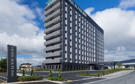A modern hotel building with a sign reading "HOTEL ROUTE INN".