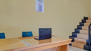 Una sala de conferencias con una mesa de madera, una computadora portátil y un calendario en la pared.