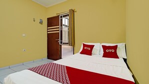 Una habitación de hotel con cama, puerta y ventana.