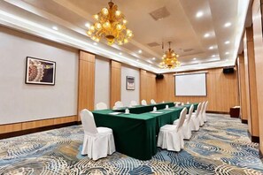 A conference room with a long table, white chairs, and a projector screen. - Inner Mongolia Hotel Duolan Hotel (Jinqiao Development Zone) (Hohhot)
