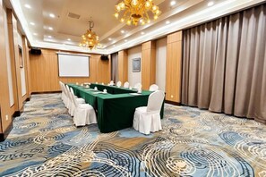 A conference room with a long table, white chairs, and a projector screen. - Inner Mongolia Hotel Duolan Hotel (Jinqiao Development Zone) (Hohhot)