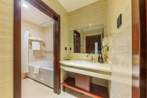 Une salle de bain moderne avec une baignoire, un double lavabo et un grand miroir.