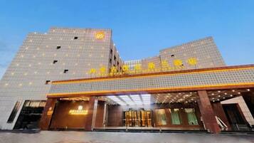 A hotel with a modern facade, a prominent entrance, and a clear sky.