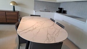Uma cozinha moderna com bancada de mármore, pia e cafeteira.