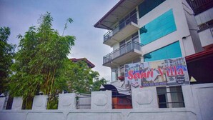 Un edificio con un letrero que dice 'Sanni Villa' y un número de contacto.