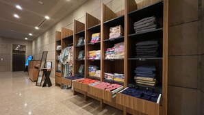Una tienda de ropa con estanterías de madera que exhiben prendas dobladas.