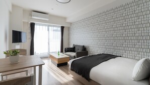 Een moderne hotelkamer met een groot bed, een bank, een eettafel en een televisie.