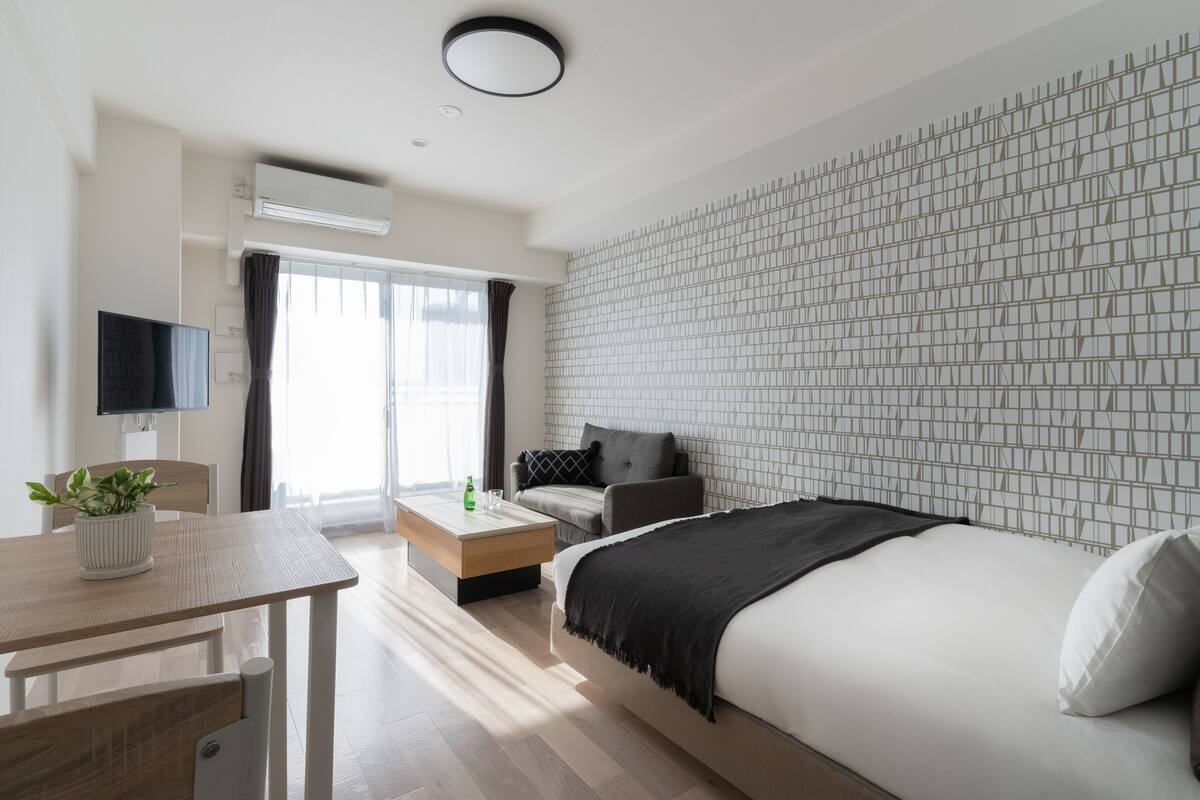Een moderne hotelkamer met een groot bed, een bank, een eettafel en een televisie.