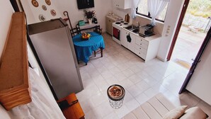 A compact living space with a kitchenette, a dining area, and a sofa. - Villa Kavalino (Κολύμπια)