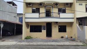A two-story building with a balcony, numbered C16, featuring a small entrance and a signboard. - Hotel O C16 Siwalankerto Syariah (Sidoarjo)