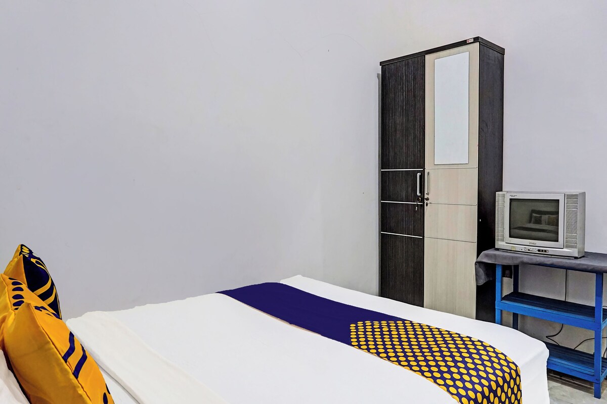 Ein Hotelzimmer mit einem Bett, einem Kleiderschrank und einem Fernseher auf einem Tisch.