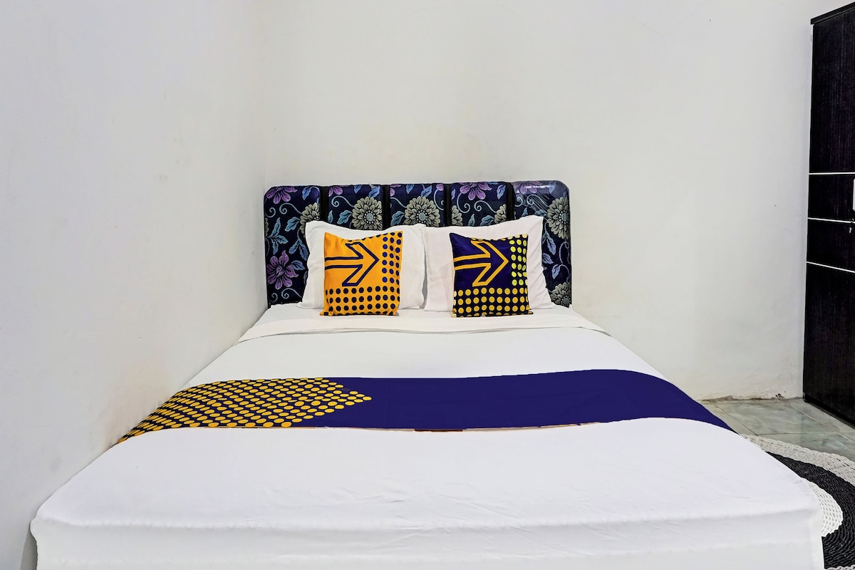 A bed with a patterned headboard and two pillows with geometric designs.